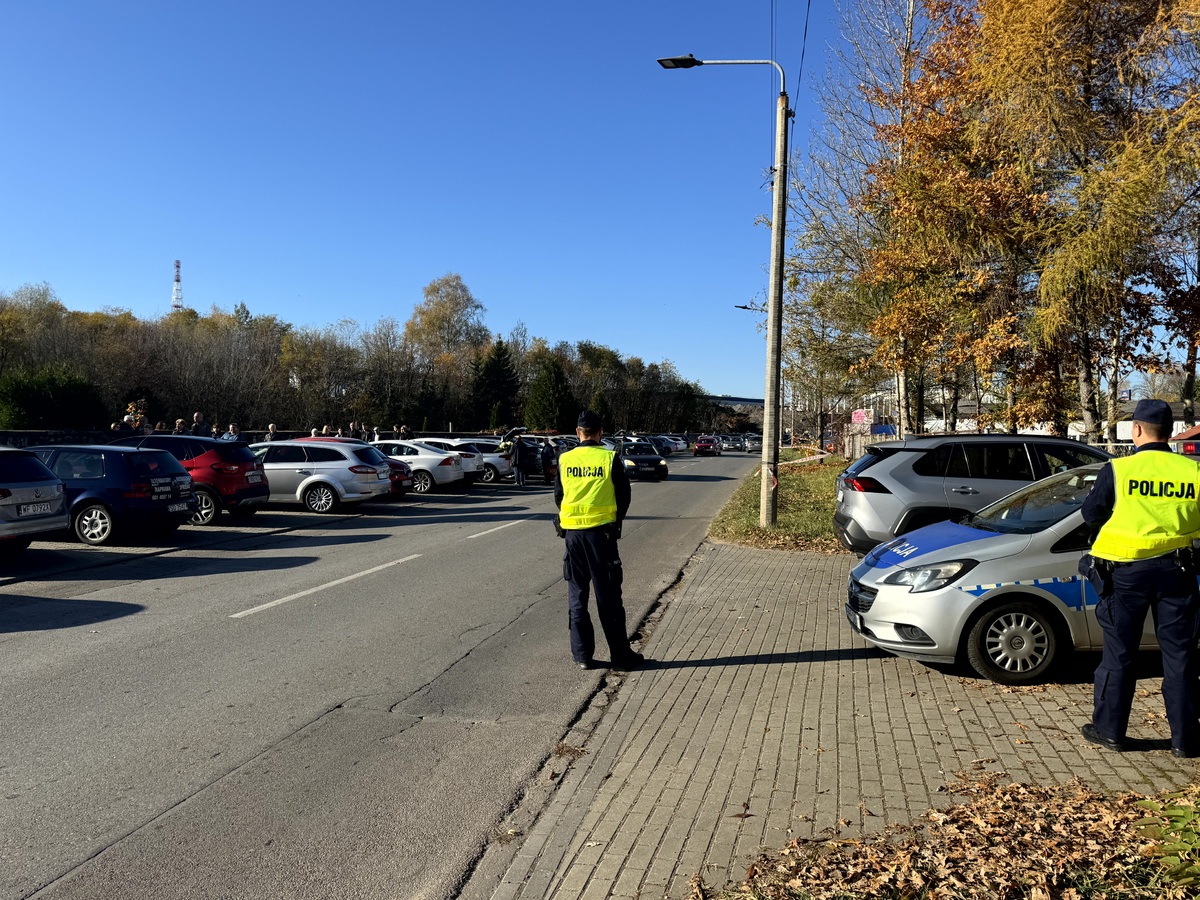 Umundurowani policjanci w odblaskowych kamizelkach kierujacy ruchem w okolicach cmentarza