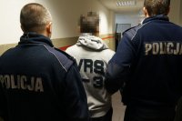 Policjanci prowadzą zatrzymanego mężczyznę