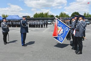 Komendant Wojewódzki Policji w Katowicach nadinsp. Krzysztof Justyński salutuje przed sztandarem Komendy Miejskiej Policji w Dąbrowie Górniczej