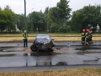 Policjant przy uszkodzonym pojeździe marki opel