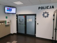 Wejście do Komendy Miejskiej Policji w Dąbrowie Górniczej oraz zamontowany po lewej stronie drzwi defibrylator.
