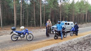 Policjanci oraz funkcjonariusze Straży Leśnej kontrolują motocyklistę