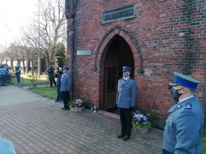 Zdjęcia przedstawiające dwóch umundurowanych galowo policjantów pełniących wartę przy kolumbarium oraz umundurowanego galowo policjanta/dowódcę uroczystości składającego hołd poległym.