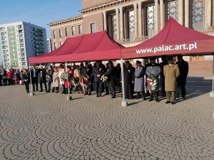 Zdjęcia przedstawiające stojących pod namiotem parlamentarzystów, władze miasta, księdza, umundurowanych funkcjonariuszy Policji, Straży Miejskiej, Straży Pożarnej i Wojska Polskiego, w tle widzimy uczestników dąbrowskiego Święta Niepodległości.