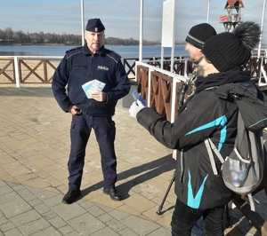 Policjant informujący przechodniów o bezpieczeństwie podczas ferii