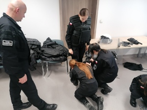 Uczniowie Klasy mundurowej podczas wizyty w komendzie policji na zajęciach prowadzonych przez umundurowanych policjantów.