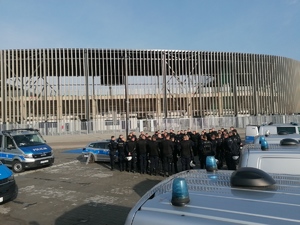 Umundurowani policjanci podczas szkolenia na stadionie piłkarskim.