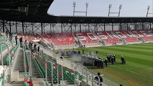 Umundurowani policjanci podczas szkolenia na stadionie piłkarskim.