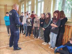 Umundurowani policjanci w trakcie szkolenia przeprowadzanego przez policjantów i kadetów klas mundurowych dla uczniów szkół podstawowych.