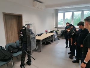 Umundurowani policjanci i kadeci klasy mundurowej podczas wizyty na zajęciach w jednostce policji.