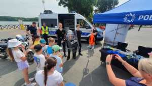 Umundurowani policjanci, strażacy, ratownicy medyczni i wodne ochotnicze pogotowie ratunkowe nad brzegiem zbiornika wodnego Pogoria 3 podczas inauguracji kampanii &quot;Kręci mnie bezpieczeństwo nad wodą&quot;