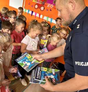 Umundurowany policjant i maskotka Sznupek na spotkaniach edukacyjnych w szkołach i przedszkolach.