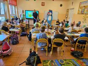 Umundurowany policjant i maskotka Sznupek na spotkaniach edukacyjnych w szkołach i przedszkolach.