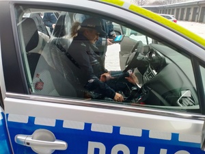 Umundurowani policjanci w nowych oznakowanych radiowozach.