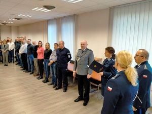 Umundurowani policjanci w trakcie uroczystości pożegnania emerytowanego funkcjonariusza.