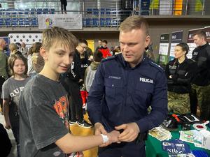 Umundurowani policjanci w trakcie pogadanek i pokazu sprzętu policyjnego na Targach Edukacji i Festiwalu Zawodów w Hali Widowiskowo-Sportowej.