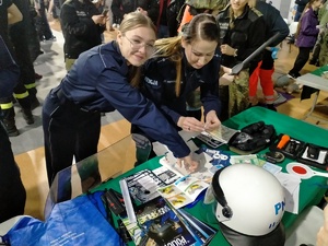 Umundurowani policjanci w trakcie pogadanek i pokazu sprzętu policyjnego na Targach Edukacji i Festiwalu Zawodów w Hali Widowiskowo-Sportowej.