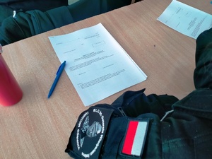 Zdjęcie przedstawia umundurowanego kadeta klasy o profilu mundurowym wypełniającego kwestionariusz.