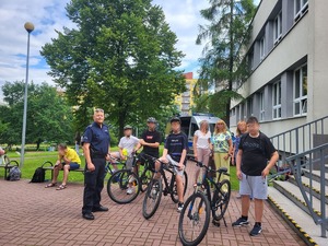 Na zdjęciu widać umundurowanego policjanta oraz dzieci które siedzą na swoich rowerach.