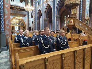 Na zdjęciu widzimy umundurowanych policjantów, księdza i ludzi uczestniczących w Mszy Świętej z okazji Święta Policji.