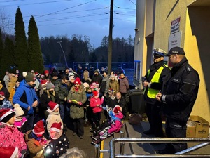 Umundurowani policjanci na spotkaniu z Mikołajem i z dziećmi.