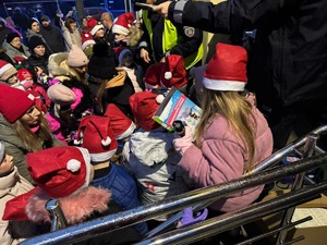 Umundurowani policjanci na spotkaniu z Mikołajem i z dziećmi.