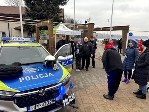 Umundurowani policjanci oraz wolontariusze podczas 33 finału Wielkiej Orkiestry Świątecznej Pomocy.