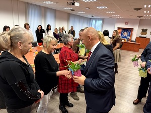 Kierownictwo dąbrowskiej policji i nieumundurowani pracownicy administracyjni podczas uroczystości w sali konferencyjnej.