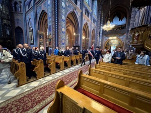 Umundurowani policjanci oraz kadeci ze szkoły mundurowej podczas uroczystej mszy świętej w kościele.