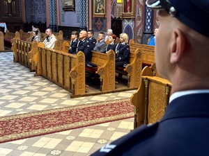 Umundurowani policjanci oraz kadeci ze szkoły mundurowej podczas uroczystej mszy świętej w kościele.