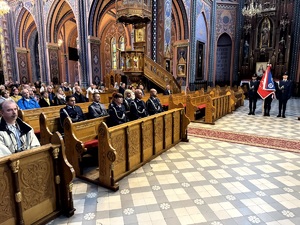 Umundurowani policjanci oraz kadeci ze szkoły mundurowej podczas uroczystej mszy świętej w kościele.