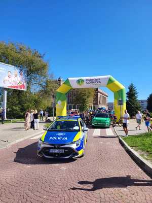 Umundurowani policjanci i oznakowane radiowozy podczas rajdu rowerowego ulicami Dąbrowy Górniczej