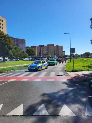Umundurowani policjanci i oznakowane radiowozy podczas rajdu rowerowego ulicami Dąbrowy Górniczej