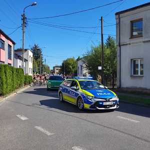 Umundurowani policjanci i oznakowane radiowozy podczas rajdu rowerowego ulicami Dąbrowy Górniczej