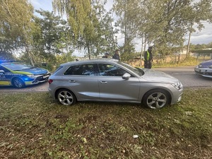 Oznakowane radiowozy i umundurowani policjanci w trakcie zatrzymywania pojazdu