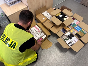 Nieumundurowany policjant liczący produkty z podrobionymi znakami towarowymi