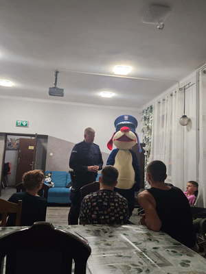 Zdjęcia przedstawiają policjanta wraz z maskotką Sznupek