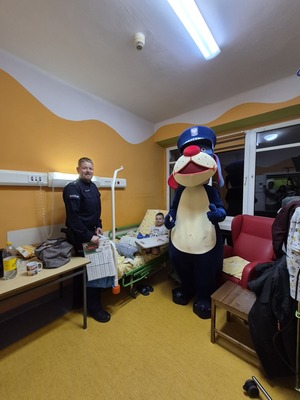 Zdjęcia przedstawiają policjanta wraz z maskotką Sznupek