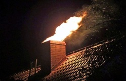 Na zdjęciu widać komin z którego wydobywa się płomień.