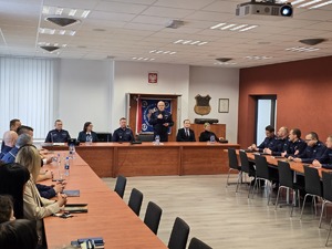 Na zdjęciu widać Policjantów oraz osoby biorące udział w odprawie.