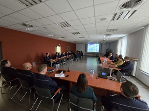 Na zdjęciu widać Policjantów oraz osoby biorące udział w odprawie.