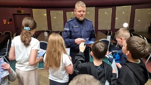 Policjant oraz osoby biorące udział w spotkaniu