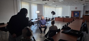 Policjant udzielający wywiadu i ekipa telewizyjna