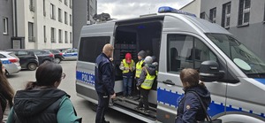 Na zdjęciu widzimy policjanta i osoby odwiedzające Komendę Miejską Policji