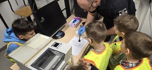 policjant pokazuje dzieciom jak wygląda zbieranie odcisków palców