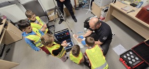Policjant pokazuje dzieciom jak wygląda praca w policji