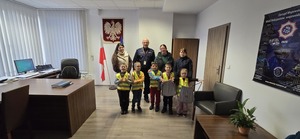 Policjant , trzy kobiety oraz pięcioro dzieci w pomieszczeniu