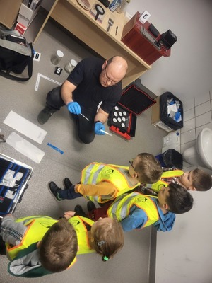 Policjant pokazuje dzieciom jak wygląda praca w policji