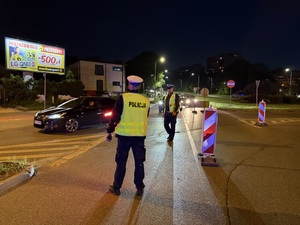 Zdjęcie przedstawia policjanta kierującego ruchem podczas zabezpieczenia I Maratonu Zagłębiowskiego w dniu 23 maja 2026 roku.