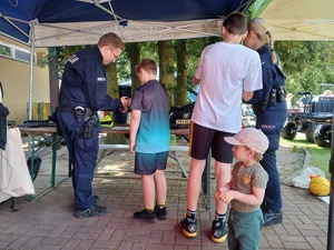 zdjęcie przedstawia umundurowanych policjantów wraz z dziećmi